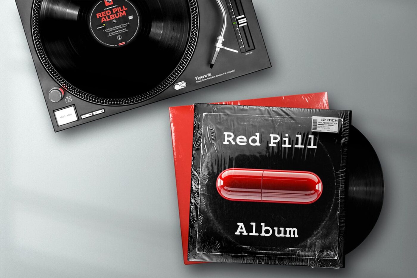A black turntable with a stack of Red Pill Album sleeves and a vinyl record beside it on a grey surface.